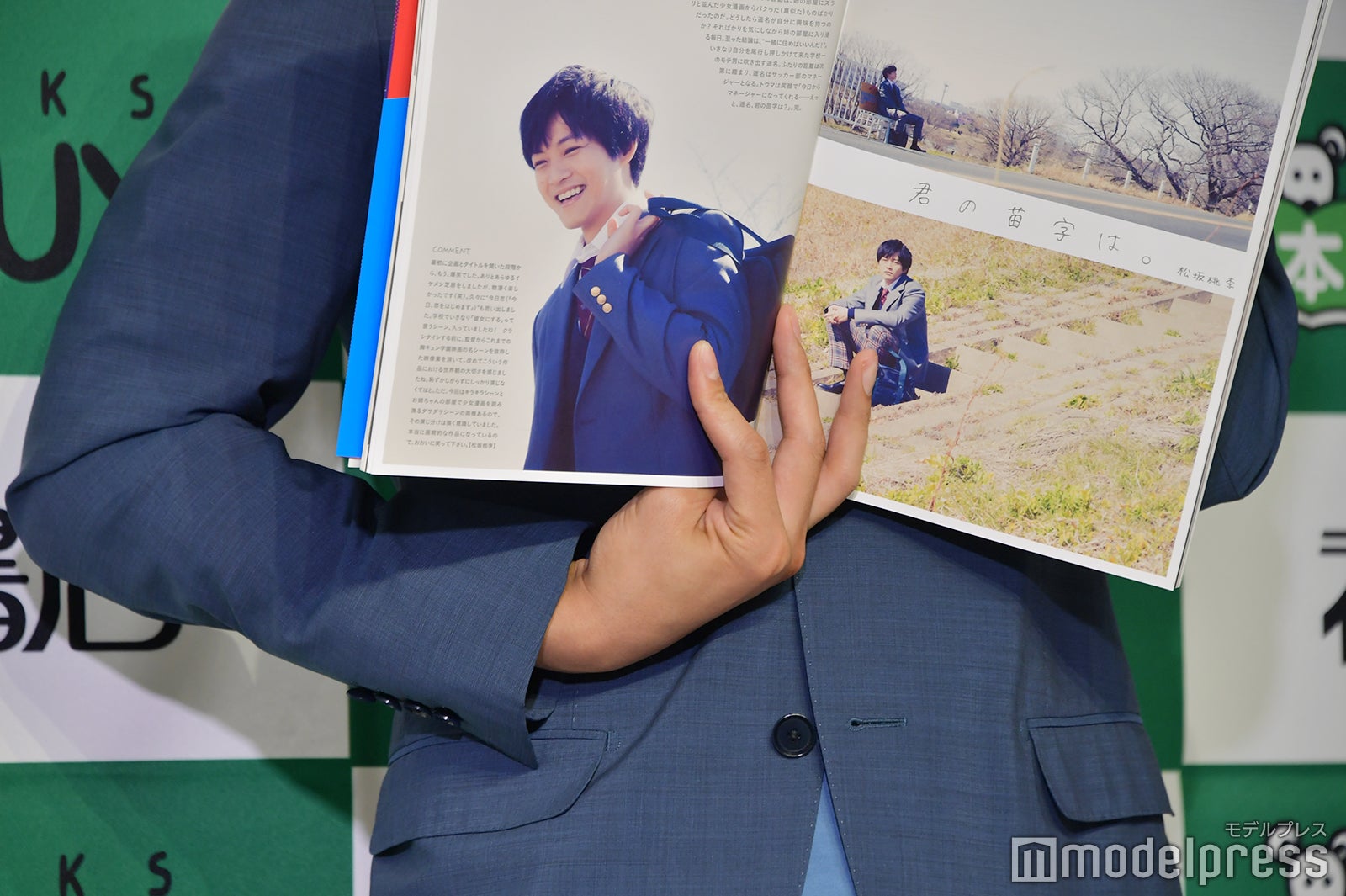 カメラマンに見やすく持つ方法を模索して指が複雑なことになっている松坂桃李 （C）モデルプレス