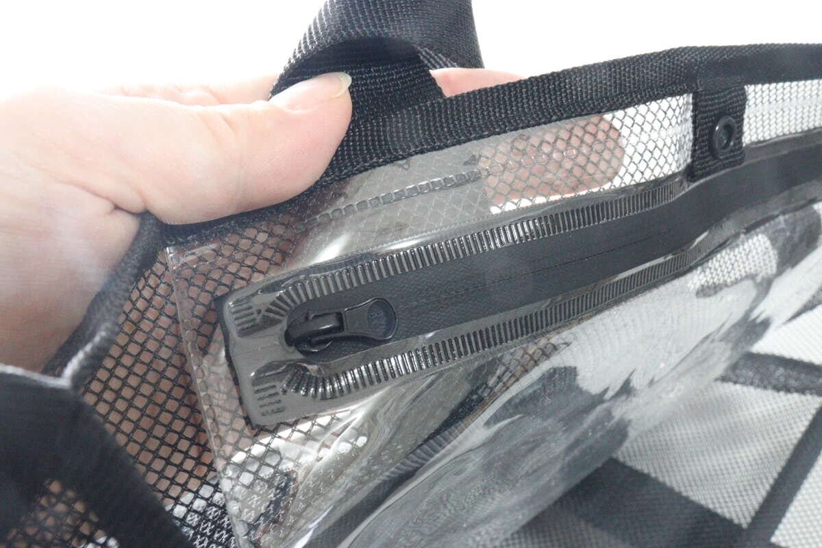 メッシュバッグの内側にある防滴袋の止水ファスナー部分を指でつまんでいる。