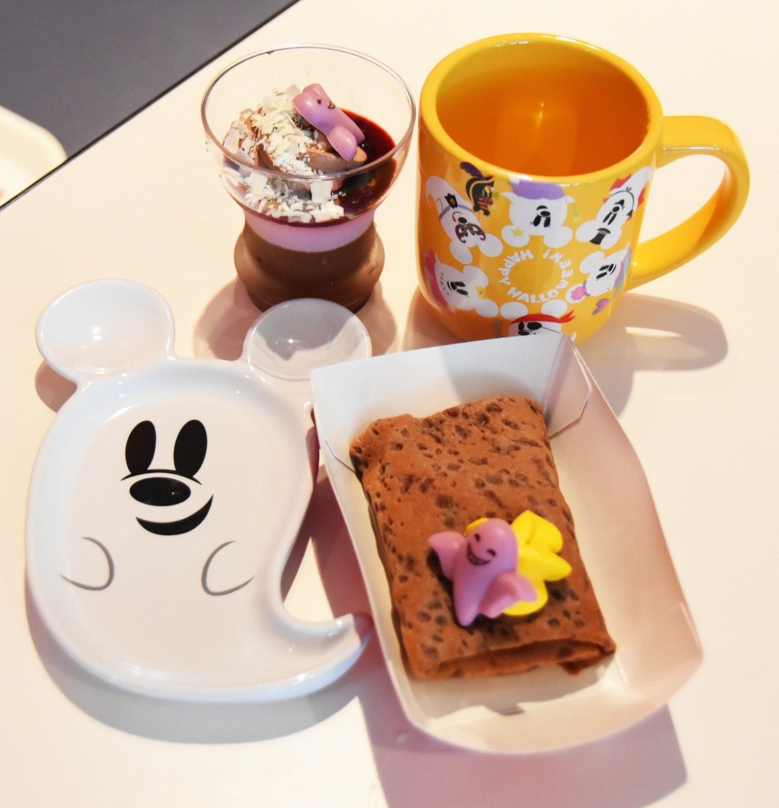 手前がスウィートポテトクレープ（550円、プラス550円でスーベニアプレート付き）、奥がカシス＆チョコムース（550円、プラス550円でスーベニアカップ付き）。東京ディズニーランド「スウィートハート・カフェ」、東京ディズニーシー「ザンビーニ・ブラザーズ・リストランテ」などで販売