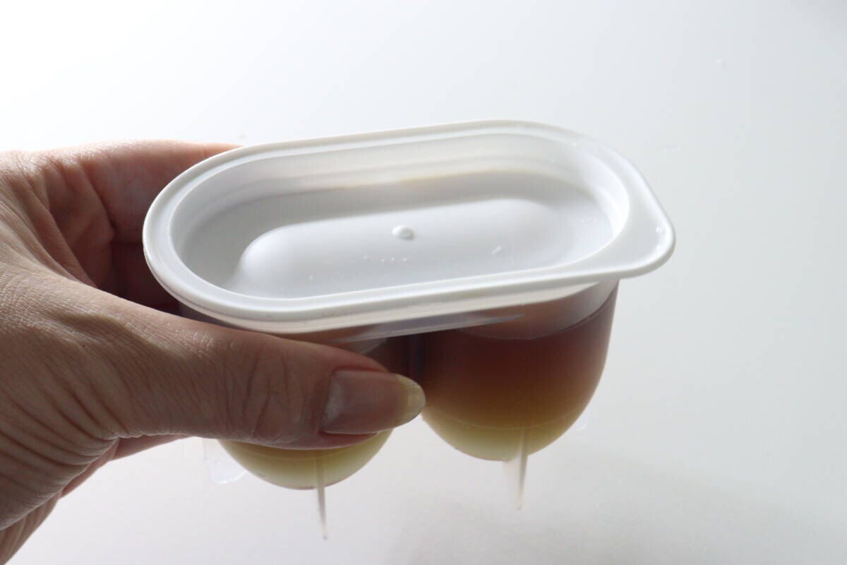 落とし蓋とフタをした味玉名人の容器を女性が手に持つ 落とし蓋とフタをした味玉名人の容器を女性が手に持つ