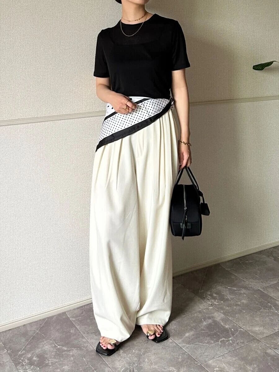 黒シアーTと白パンツにスカーフを巻いた女性