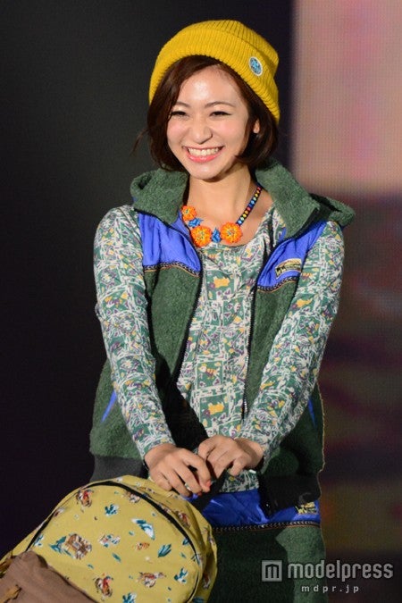 マスタードイエローのビーニーが着こなしのポイントに。ベストにスニーカー、リュックを合わせた王道カジュアル。