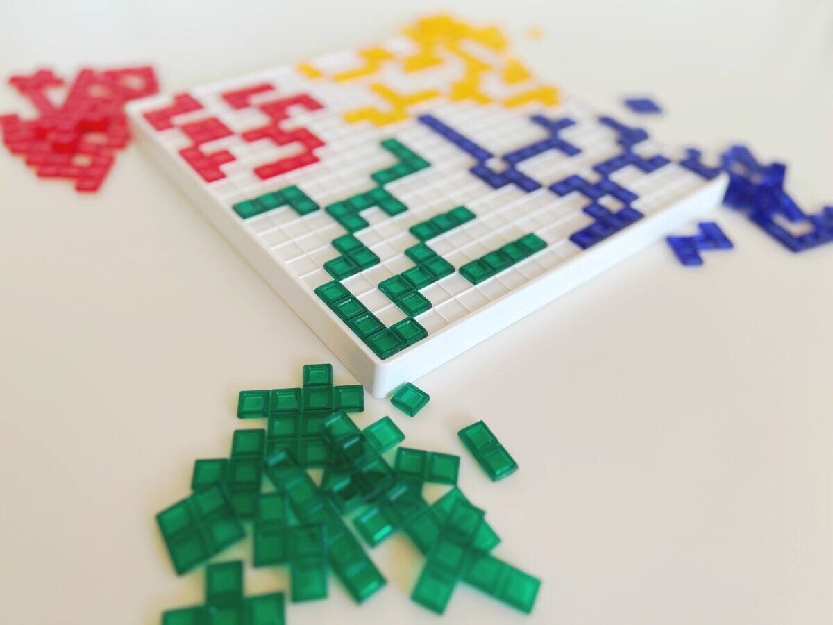 赤・黄・緑・青の4色のパズルピースが色ごとに陣地分けされたゾーニングを表すイメージ写真