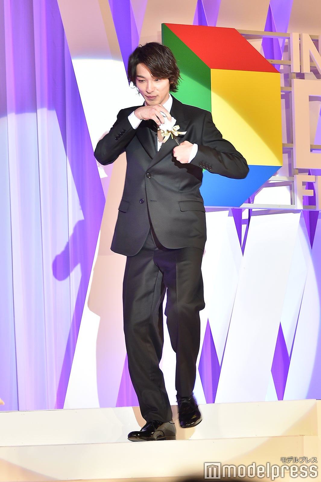 胸ポケットの花が落ちてしまい拾った横浜流星 （C）モデルプレス