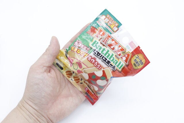 ダイソーのピザバスボールのパッケージを手に持った様子