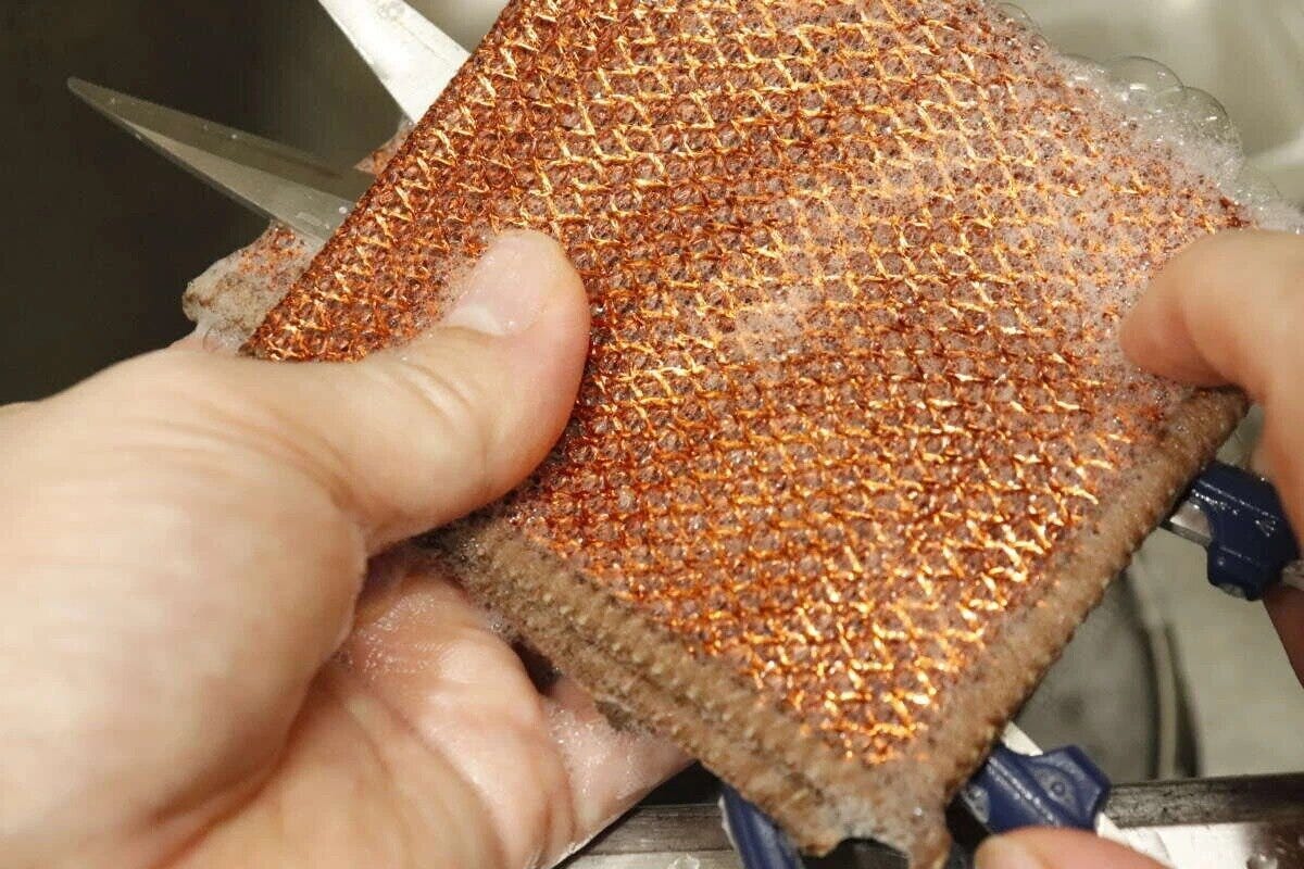 茶色のダブルメッシュクロスで泡立てながらキッチンバサミを洗う手元