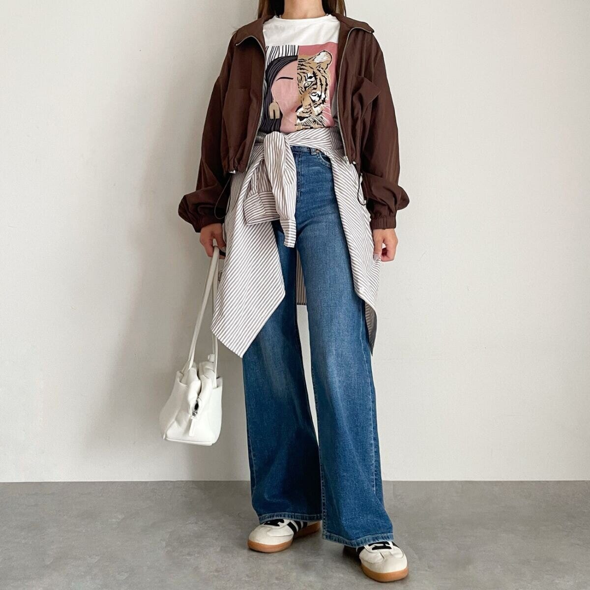 プリントTシャツにストライプシャツを腰巻きしたこなれ感のある服装