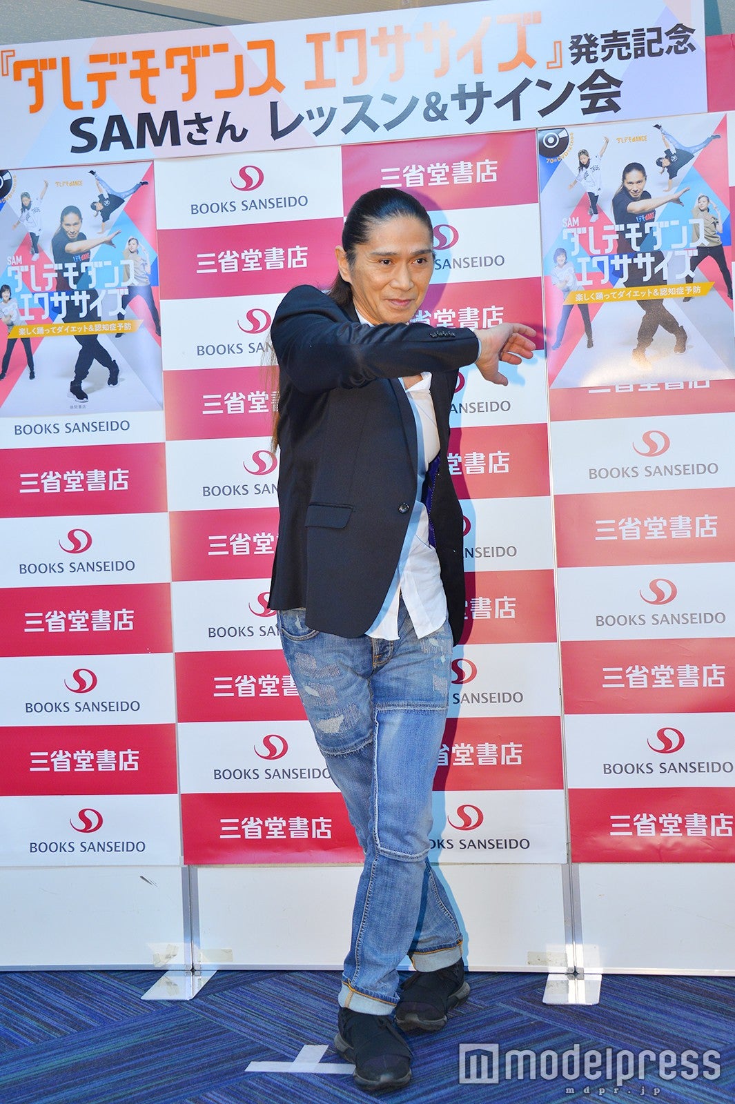 表紙のポーズを再現するSAM（C）モデルプレス