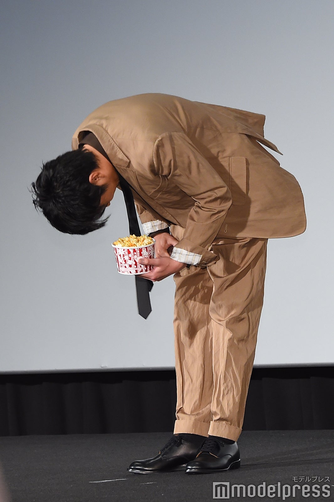 ポップコーンを持ったまま深々とお辞儀をする田中圭（C）モデルプレス