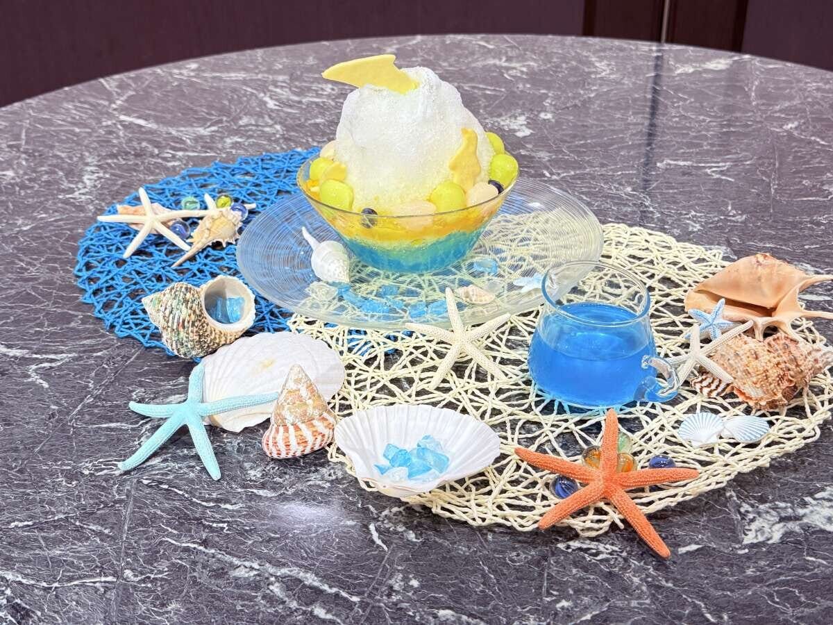 貝殻やヒトデで飾られたテーブルに置かれた青いかき氷