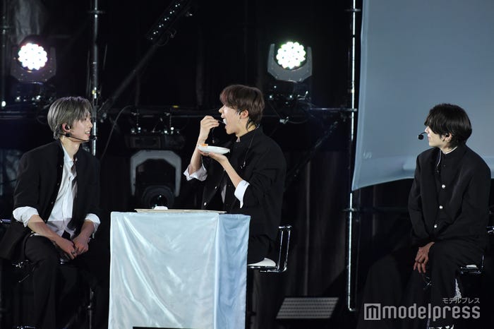 大好きなみかんの大福をまるごと口に入れたEJ(中央)、見守るFUMA(左)、YUMA(右)(C)モデルプレス