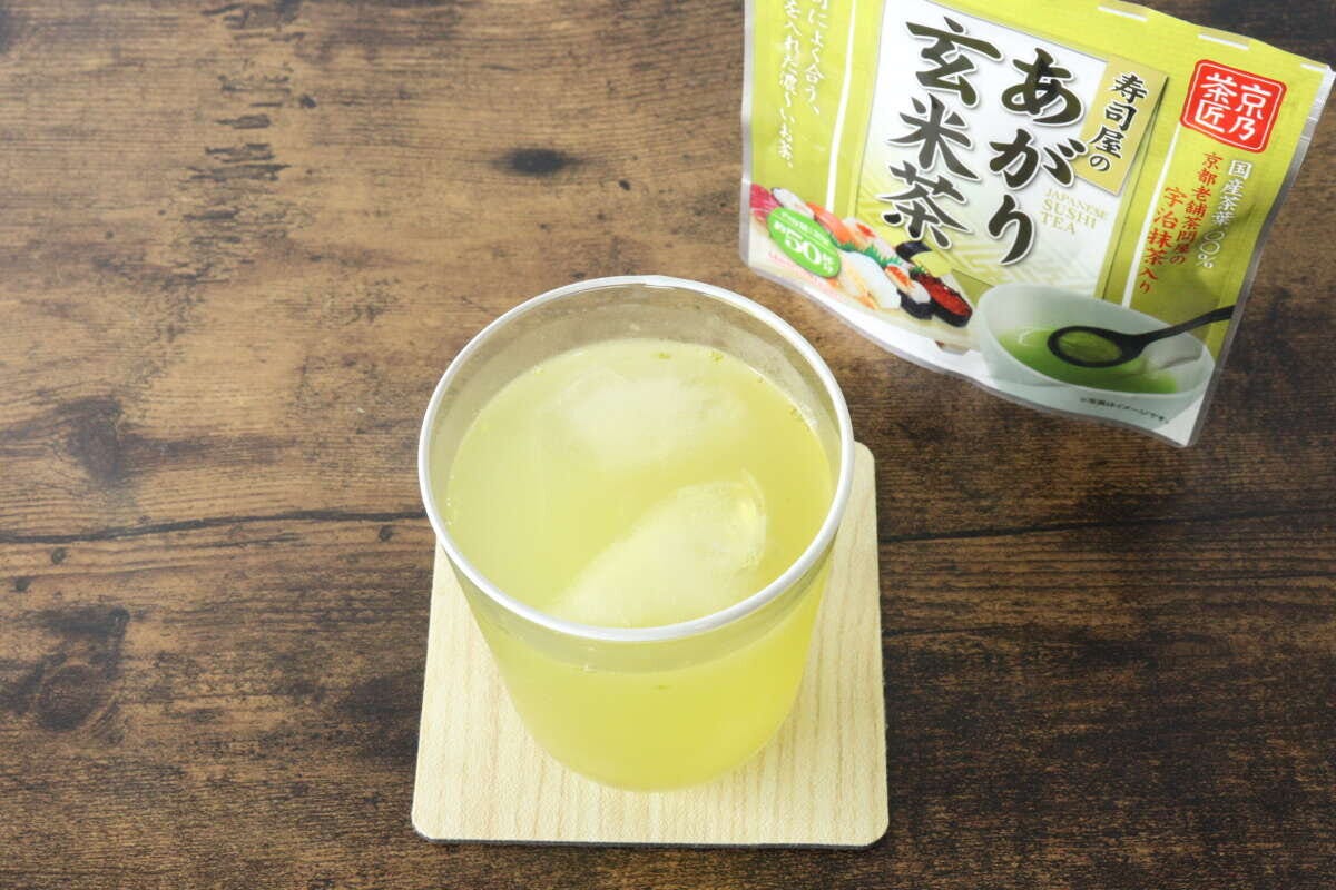 グラスに入った水出しの玄米茶と、奥に「寿司屋のあがり玄米茶」パッケージ グラスに入った水出しの玄米茶と、奥に「寿司屋のあがり玄米茶」パッケージ