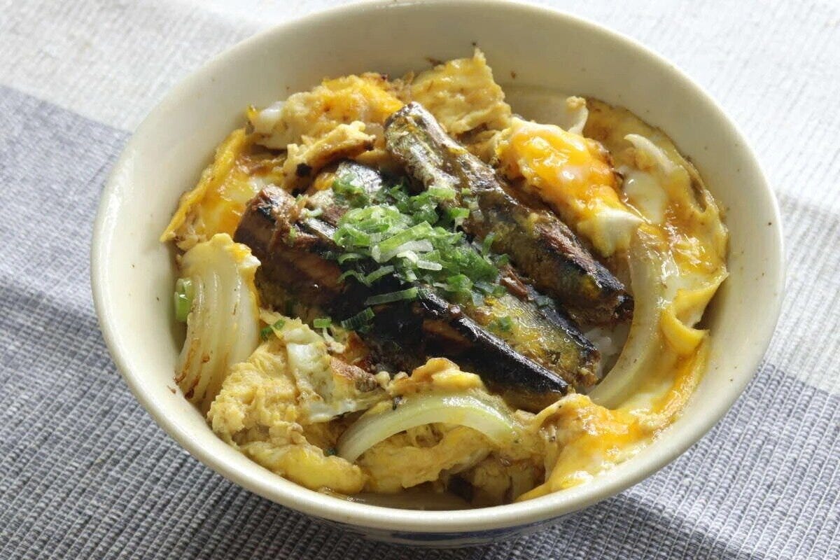 いわし醤油煮と卵、玉ねぎが乗った丼ぶりを上から撮影