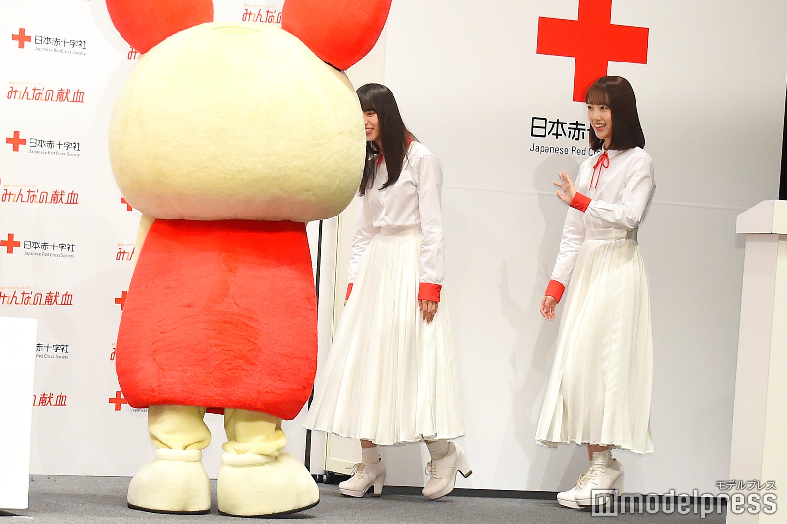 けんけつちゃんにお辞儀をする齋藤飛鳥、手を振る堀未央奈 （C）モデルプレス