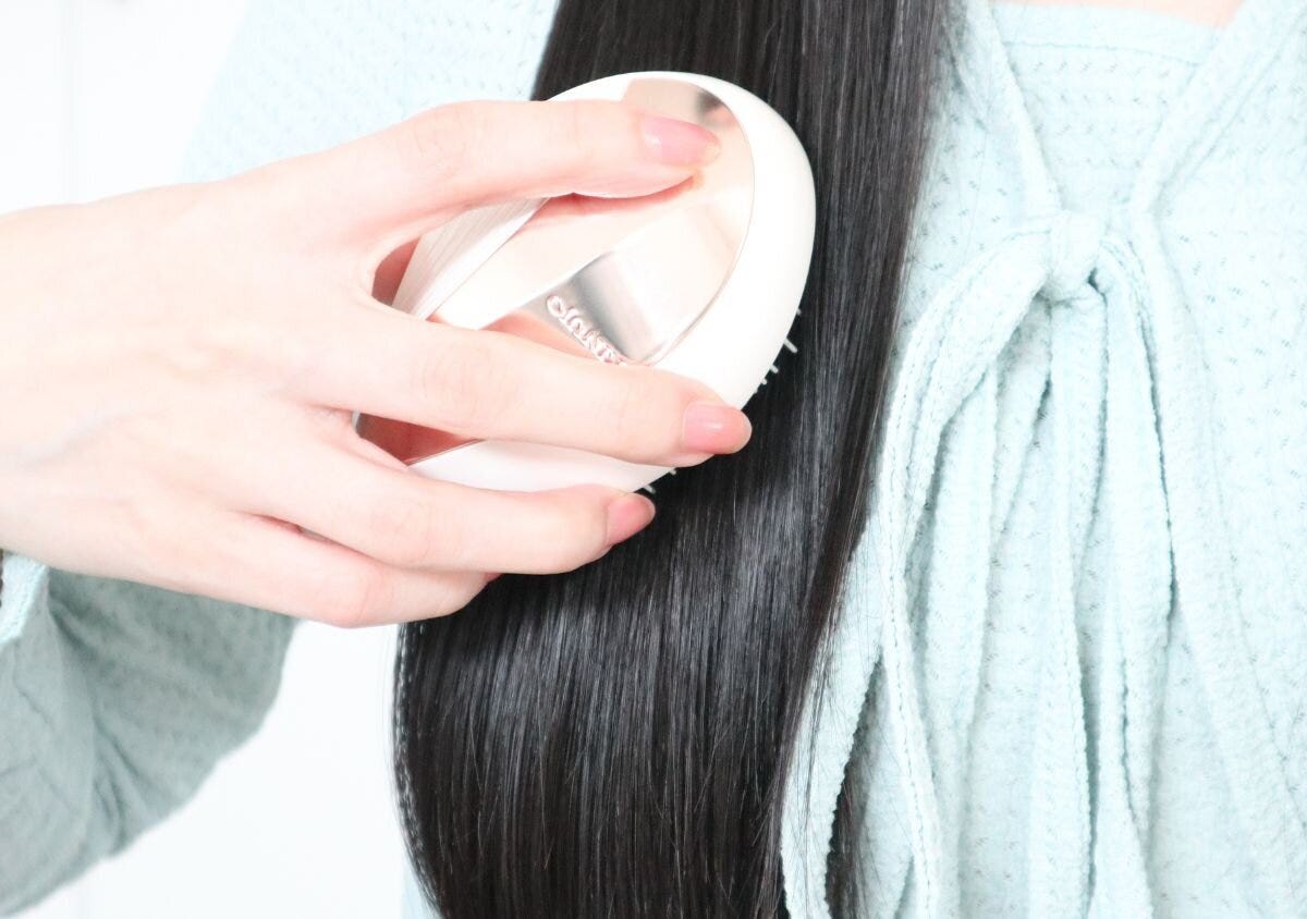 KINUJOシルキージュエルブラシで長い髪をブラッシングする女性
