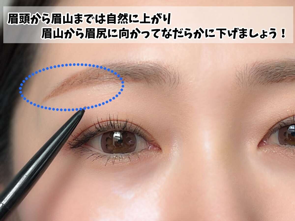 眉ペンシルで眉を描き、眉のカーブを青い点線で囲んで説明している女性の顔のアップ