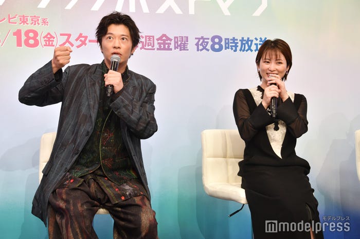 志田未来が自転車に跨り自分で日傘をさしている姿を再現する田中圭(C)モデルプレス