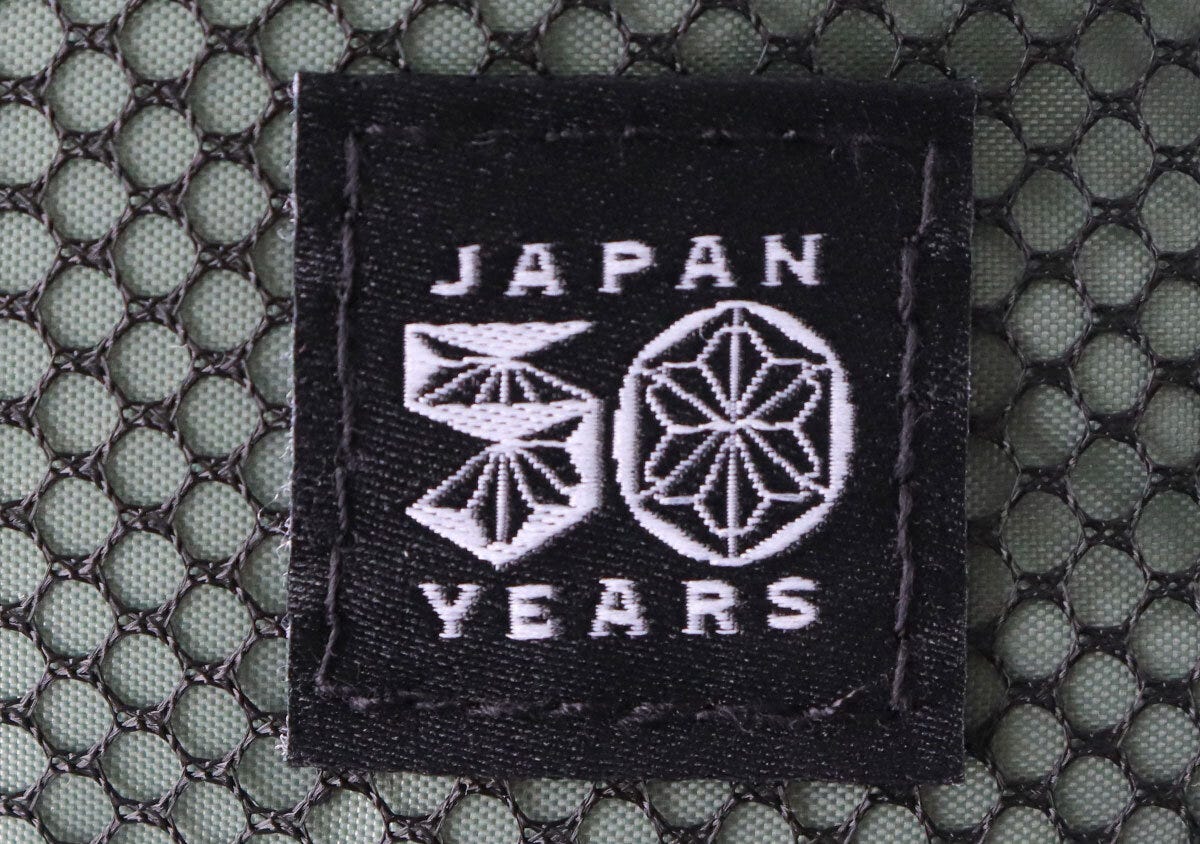 コールマン50周年記念ロゴが刺繍された黒いタグのクローズアップ コールマン50周年記念ロゴが刺繍された黒いタグのクローズアップ