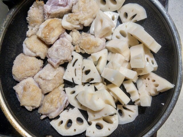 鶏もも肉を、皮目を下にして入れ、焼き色が付いたら裏返して片側に寄せ、れんこんを加えて焼き付けます。 鶏もも肉を、皮目を下にして入れ、焼き色が付いたら裏返して片側に寄せ、れんこんを加えて焼き付けます。