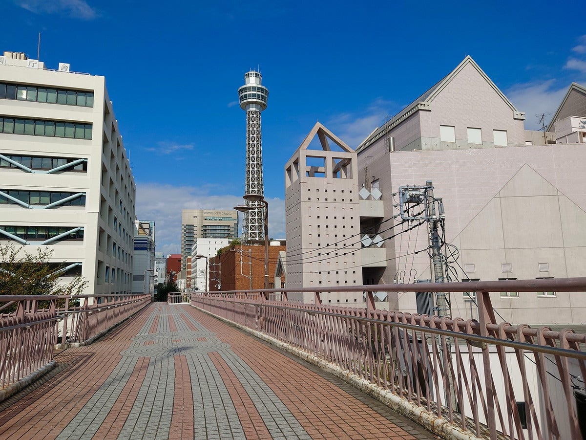 フランス橋(歩道橋)を駆け抜ける誠司の背後には横浜マリンタワーの姿が