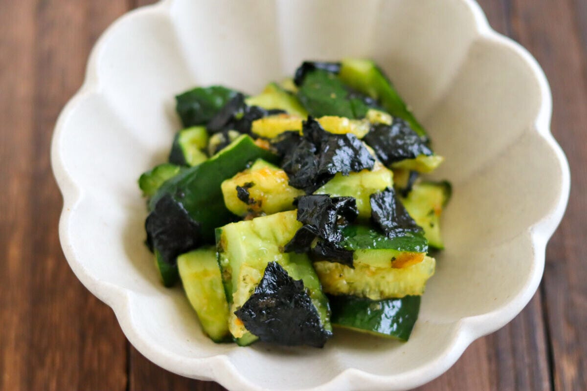 たたききゅうりの海苔和えが白い花形の器に盛り付けられ、木製の箸が添えられている俯瞰 たたききゅうりの海苔和えが白い花形の器に盛り付けられ、木製の箸が添えられている俯瞰