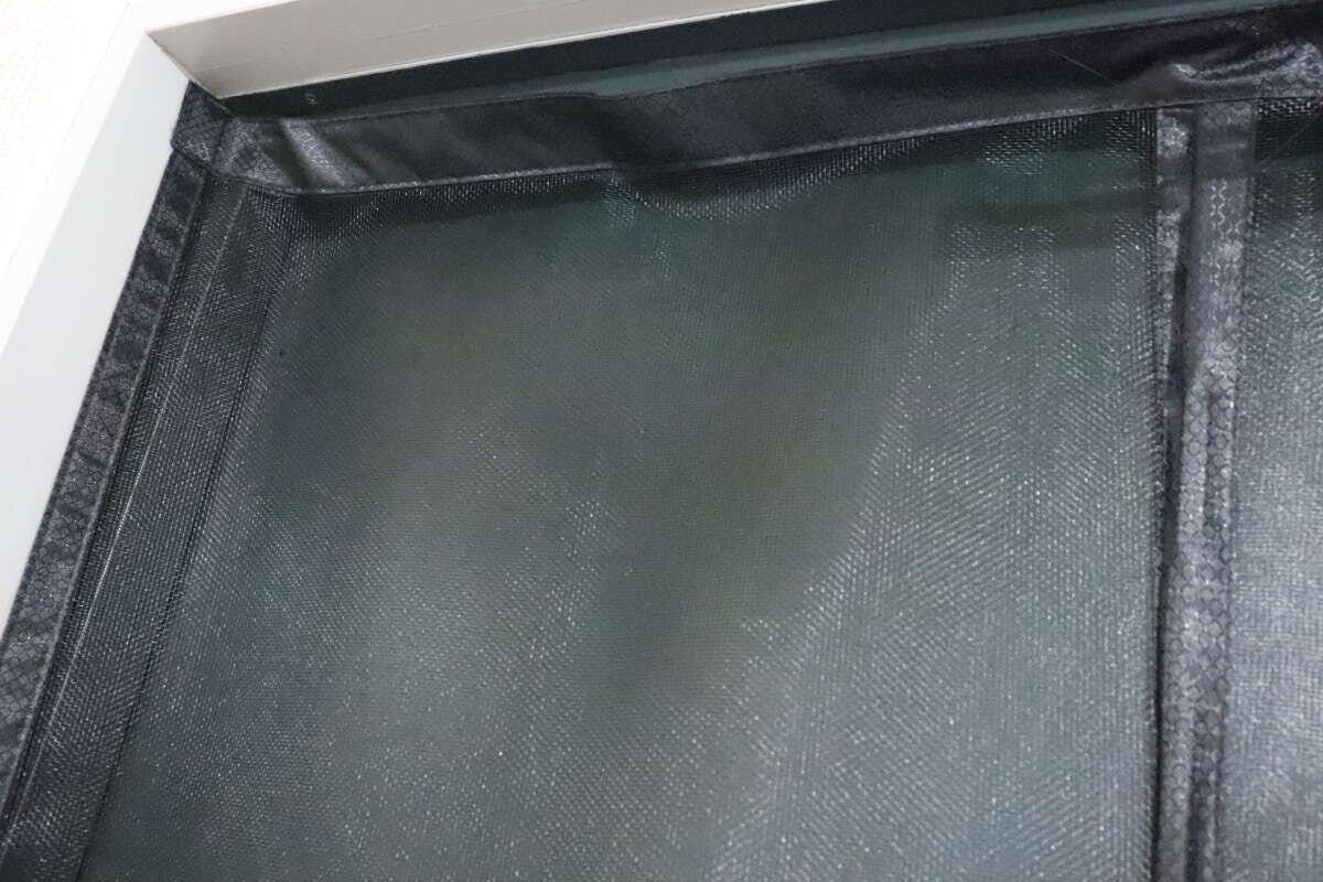 ドア枠に取り付けられたマグネット式網戸の上部が写っている