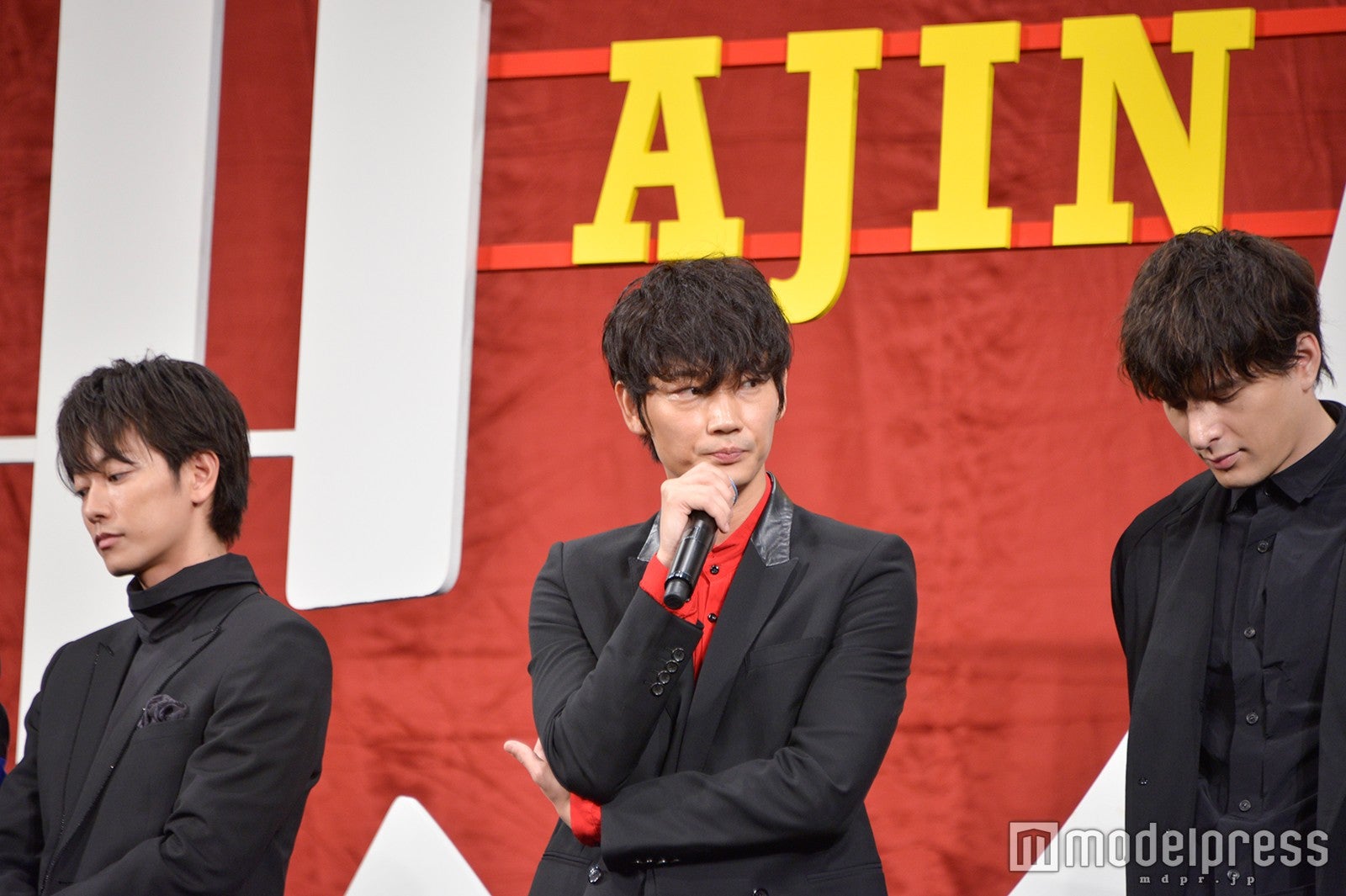 マイクをとりあえず持ってみる綾野剛と笑いをこらえる佐藤健＆城田優（C）モデルプレス