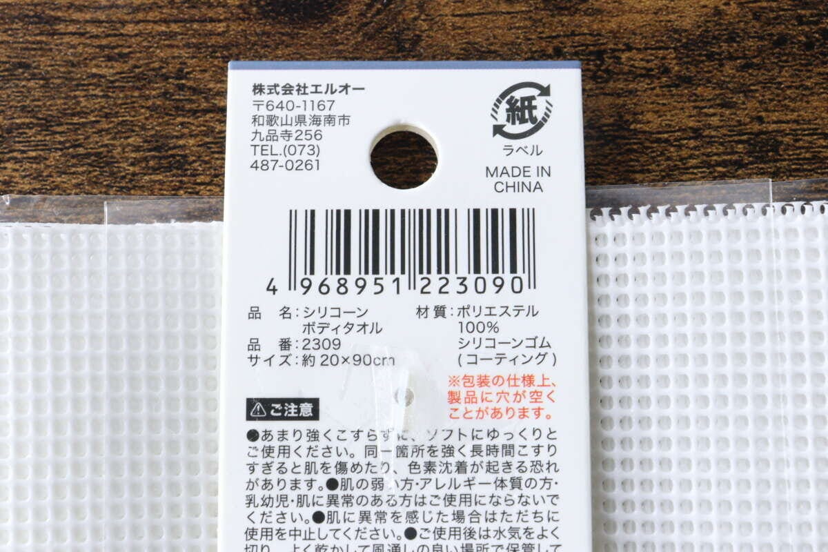 白いシリコーンボディタオルのパッケージ裏面にある商品情報とバーコードのアップ 白いシリコーンボディタオルのパッケージ裏面にある商品情報とバーコードのアップ
