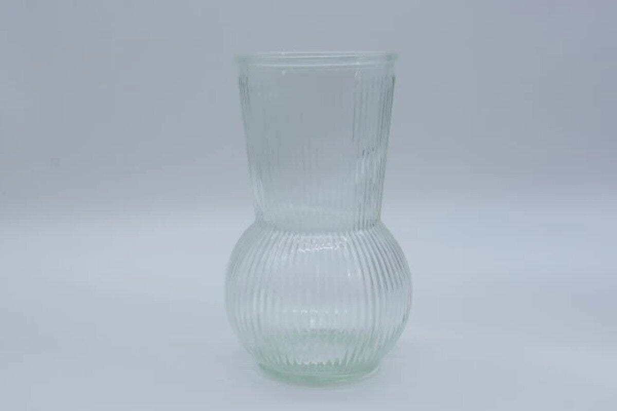 縦リブ模様の透明なガラスフラワーベースが白い背景に置かれている 縦リブ模様の透明なガラスフラワーベースが白い背景に置かれている