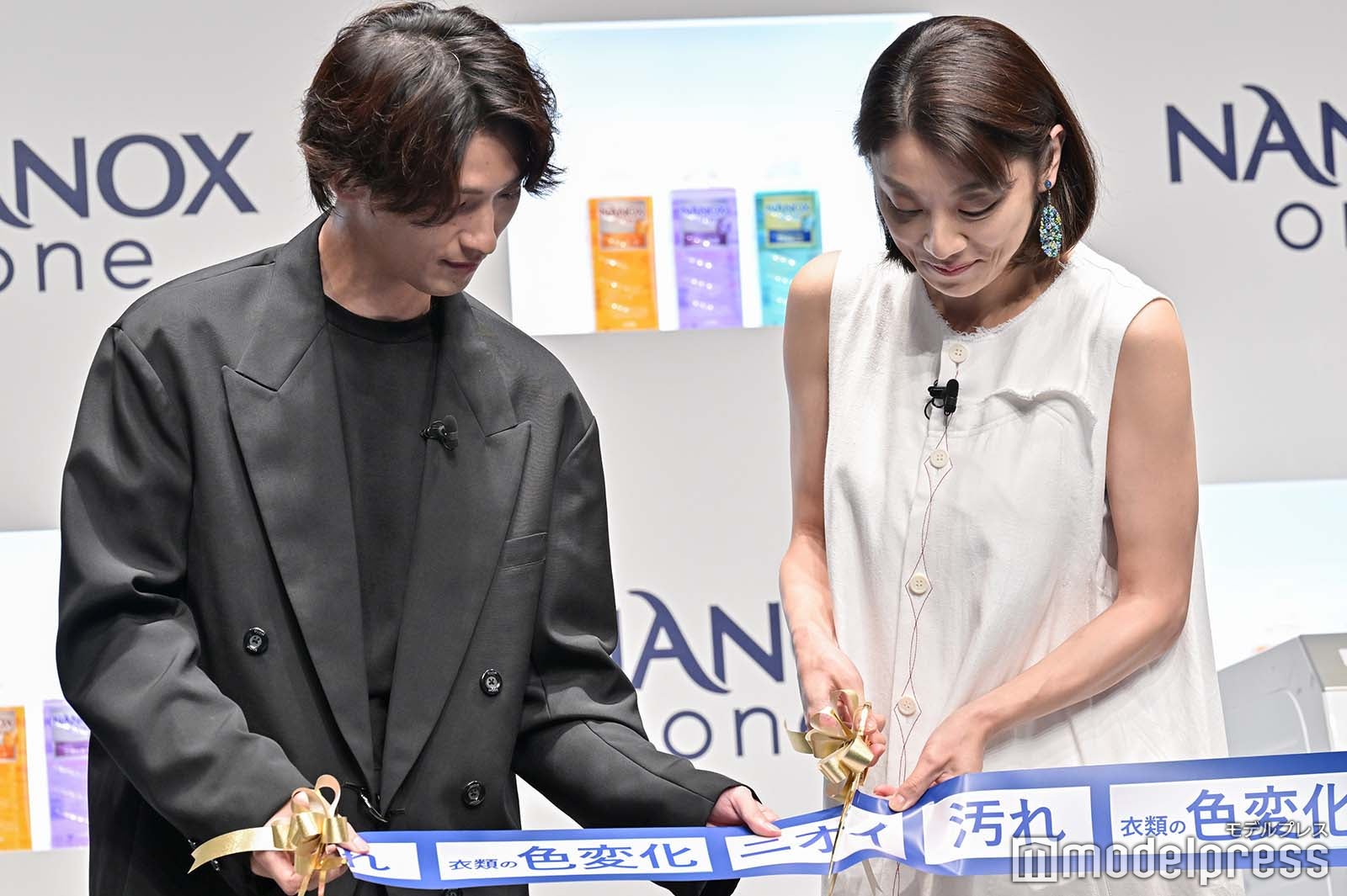 テープを支えて小池栄子をフォローする横浜流星（C）モデルプレス