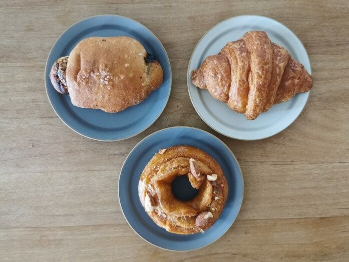 手前より時計回りに「オールドファッション　ソルティキャラメルアーモンド」、「塩パン江戸前しょうゆ」、「VEGANクロワッサン」