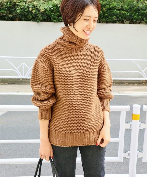 ブラウンニットとデニムパンツコーデの女性