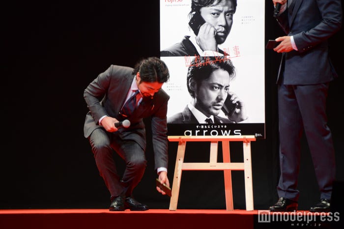 スマホの耐久性を見せるためにわざと落として小芝居をはじめようとする山田孝之「あっ…!」(C)モデルプレス