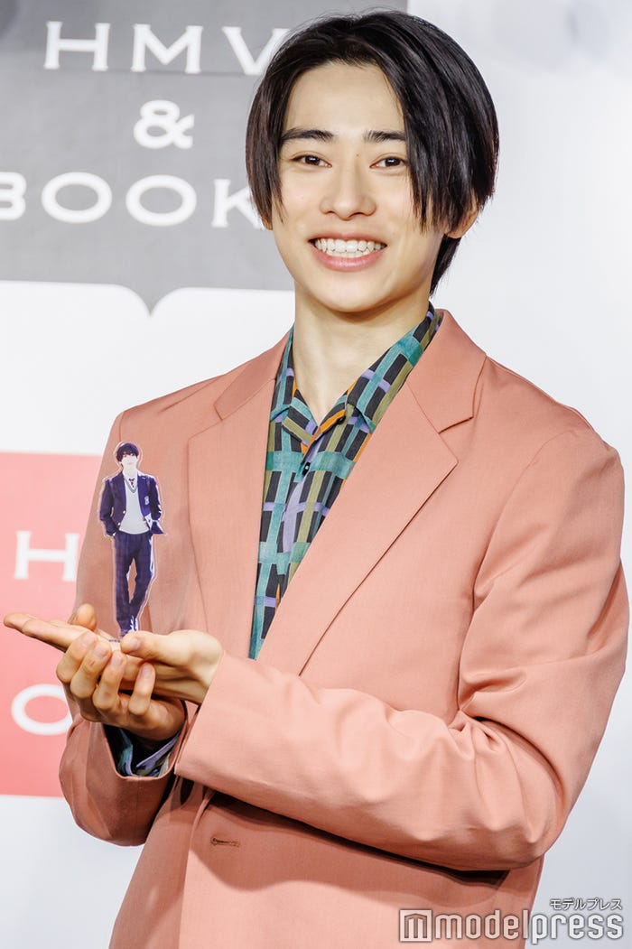 アクリルスタンドをアピールする本島純政(C)モデルプレス