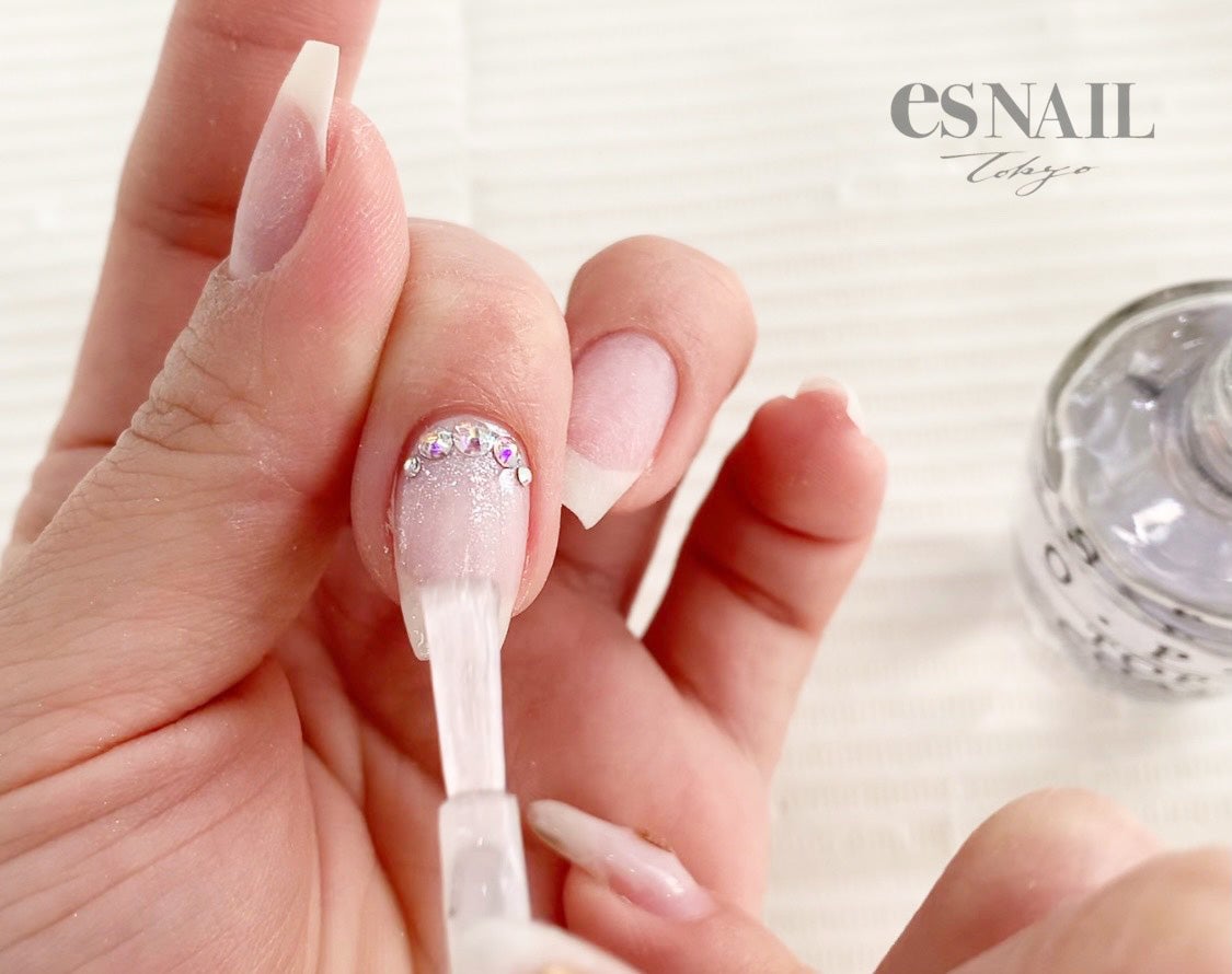 ストーンを乗せている部分は、筆先を使ってパーツの隙間に行き渡るようにトップコートを広げるのがコツ（画像提供：esNAIL）