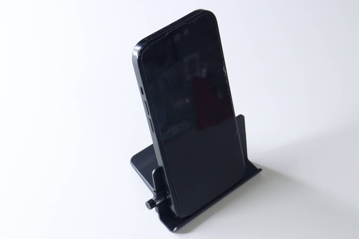 組み立てられた黒いスマホスタンドに、黒いスマートフォンが縦置きされている。