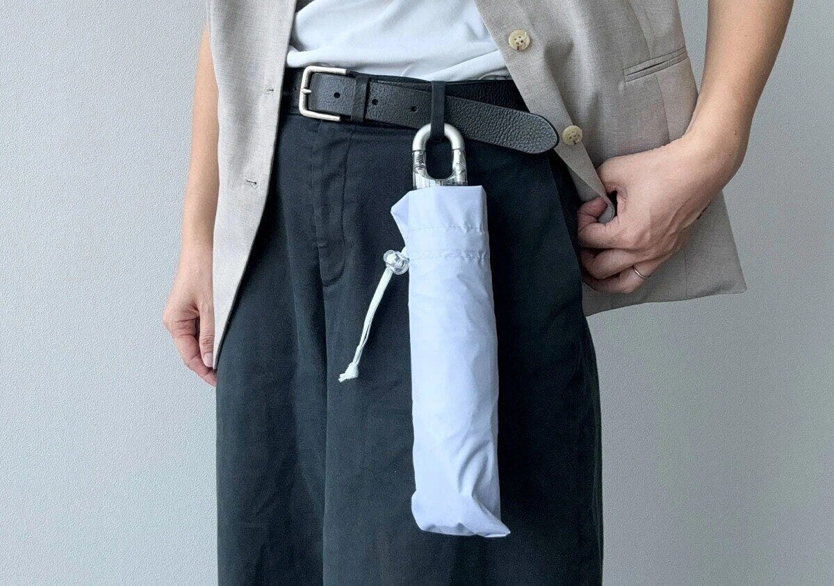 男性がベルトにカラビナ付き折りたたみ傘を装着 男性がベルトにカラビナ付き折りたたみ傘を装着