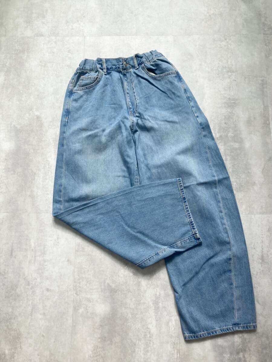 明るいブルーのバレルジーンズが床に広げられている