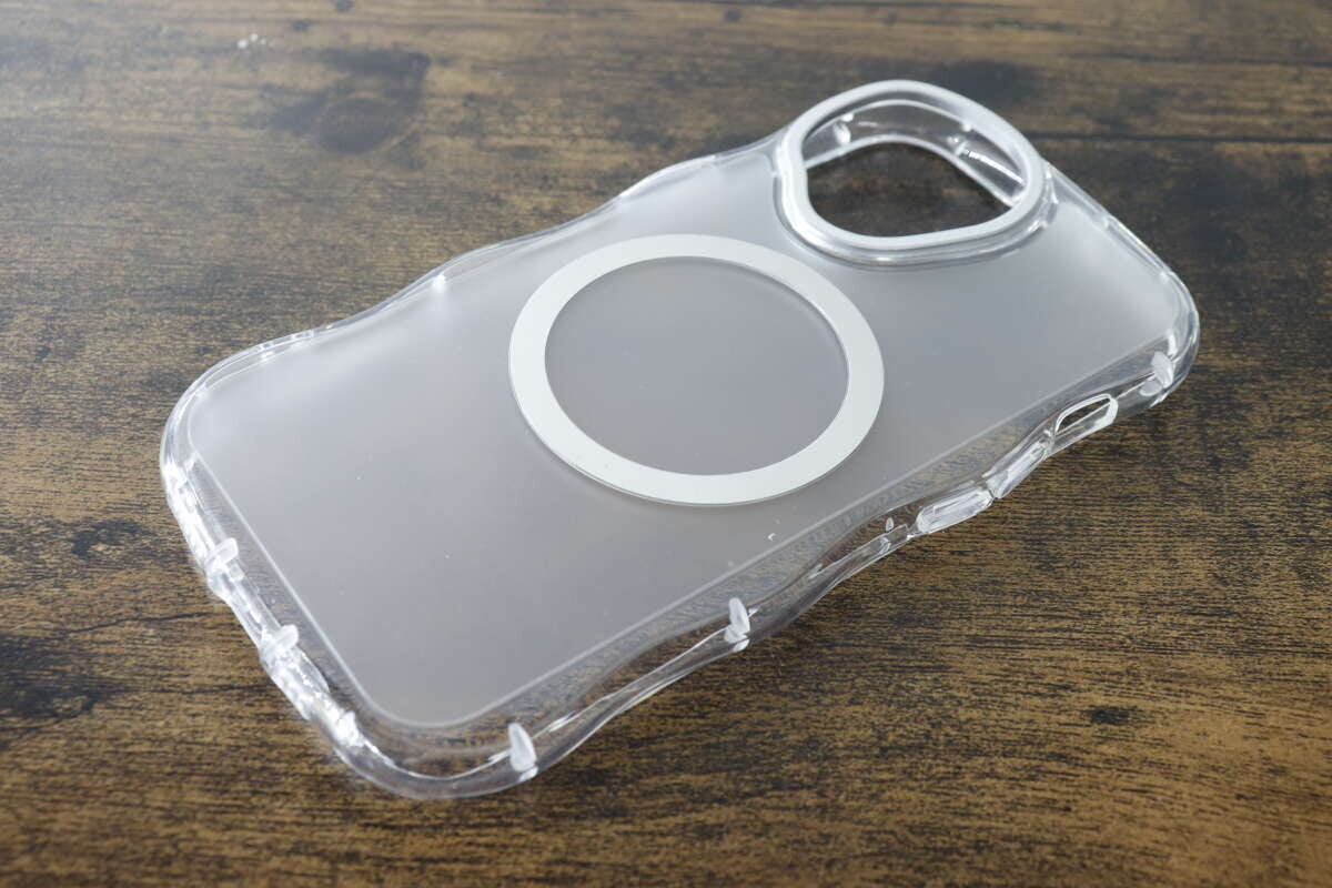 木目のテーブルに置かれたクリアなウェーブデザインのiPhoneケース
