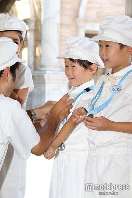 記念メダルをかけてもらい嬉しそうな涼介くん（C）Disney