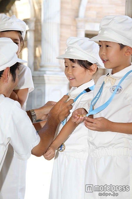 記念メダルをかけてもらい嬉しそうな涼介くん(C)Disney