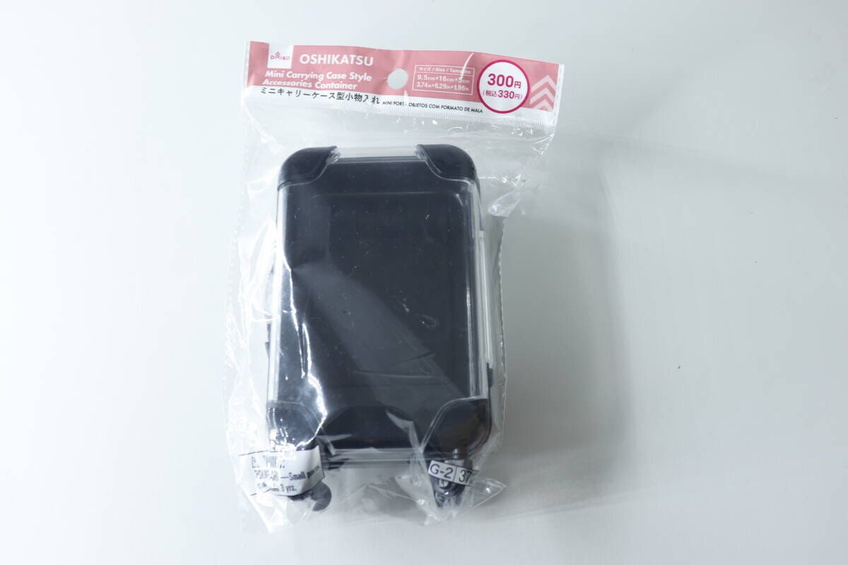 透明な袋に入った黒いミニキャリーケース型小物入れ