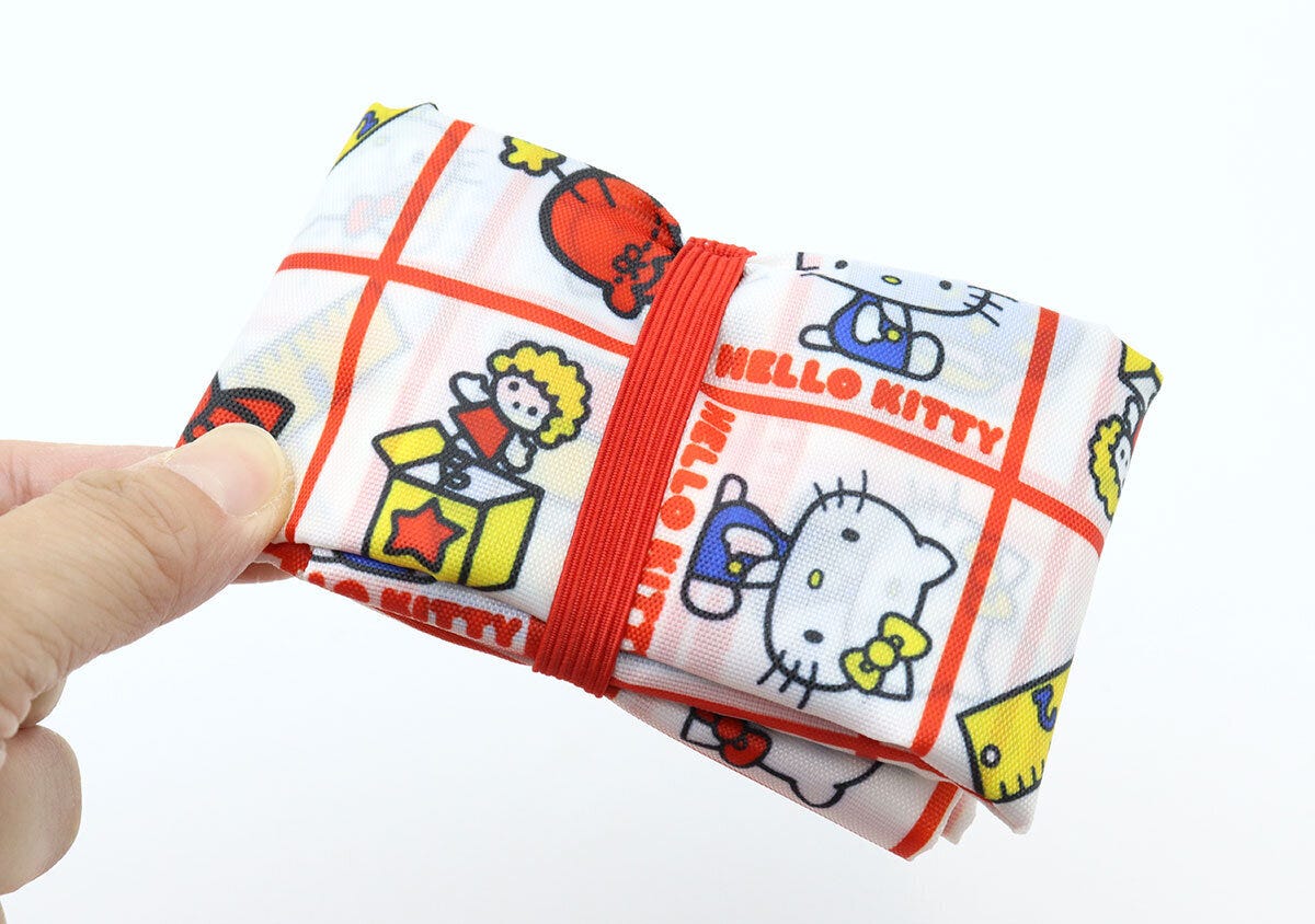 赤いゴムでコンパクトにたたまれたエコバッグを持つ手 赤いゴムでコンパクトにたたまれたエコバッグを持つ手