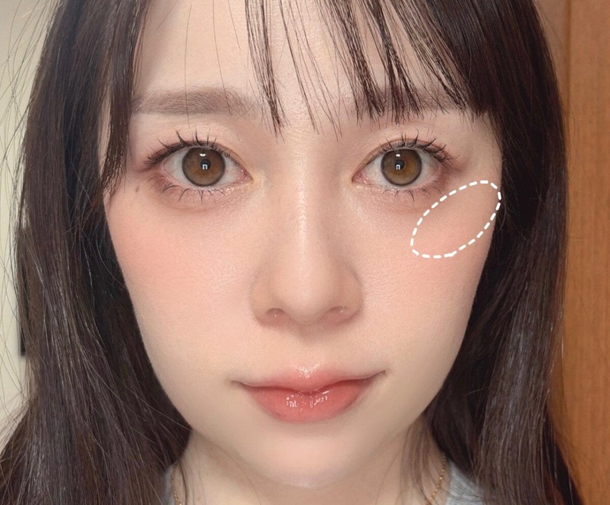 頬の高い位置からこめかみへチークを重ねる範囲を点線で示した手順