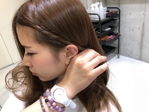 わけとった前髪をねじりながら耳うらに持っていく