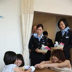 入院している患者へ「すずらんの花」を贈呈したAKB48(左から:鈴木まりや、宮澤佐江)とANA客室乗務員