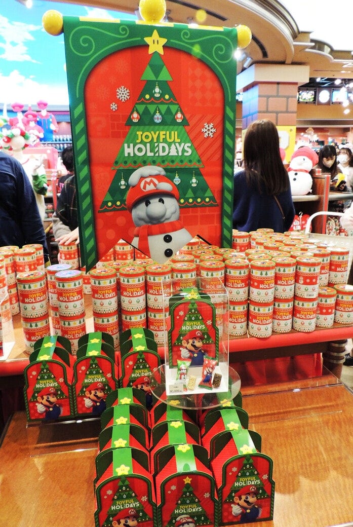 マリオとツリーがパッケージのチョコレートクランチ 24個入り1500円（手前）と、アソートクッキー缶 12個入り1700円（奥）。「ワンナップ・ファクトリー」などで販売