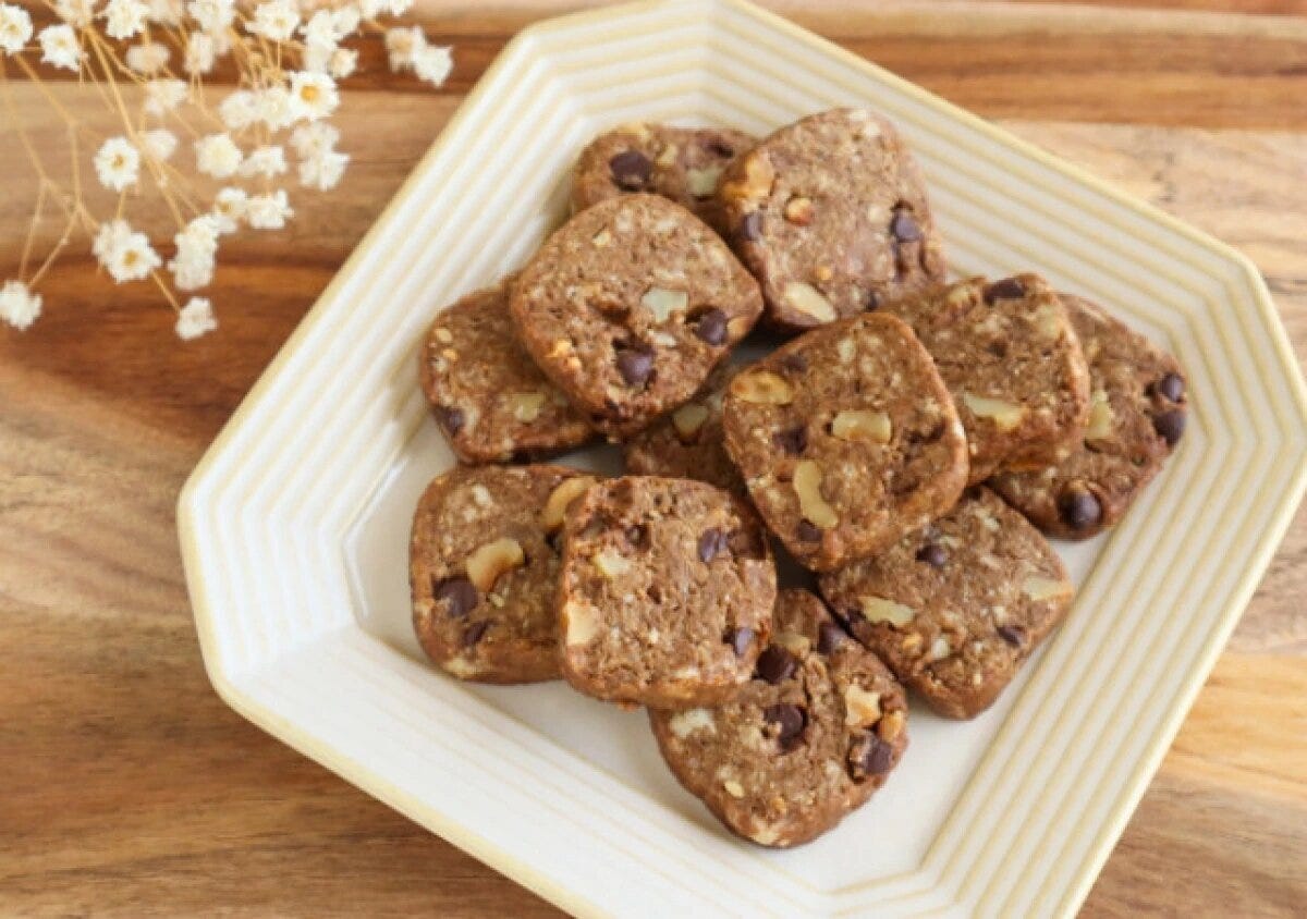 皿に盛ったカフェモカクッキー 白に黄色い縁の八角形の皿に盛られた、チョコチップとくるみ入りの四角いカフェモカクッキー
