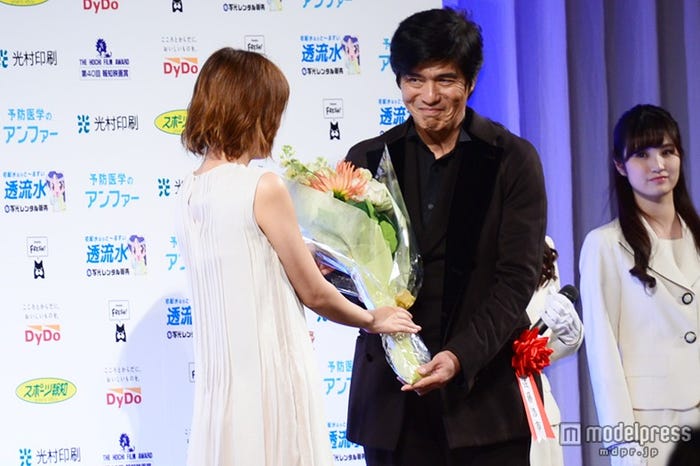 佐藤浩市(右)に花束を贈呈する本田翼(左)