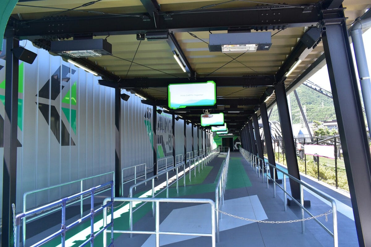 アトラクション入口からエントランスまでの通路から、疾走するコースターが見えます